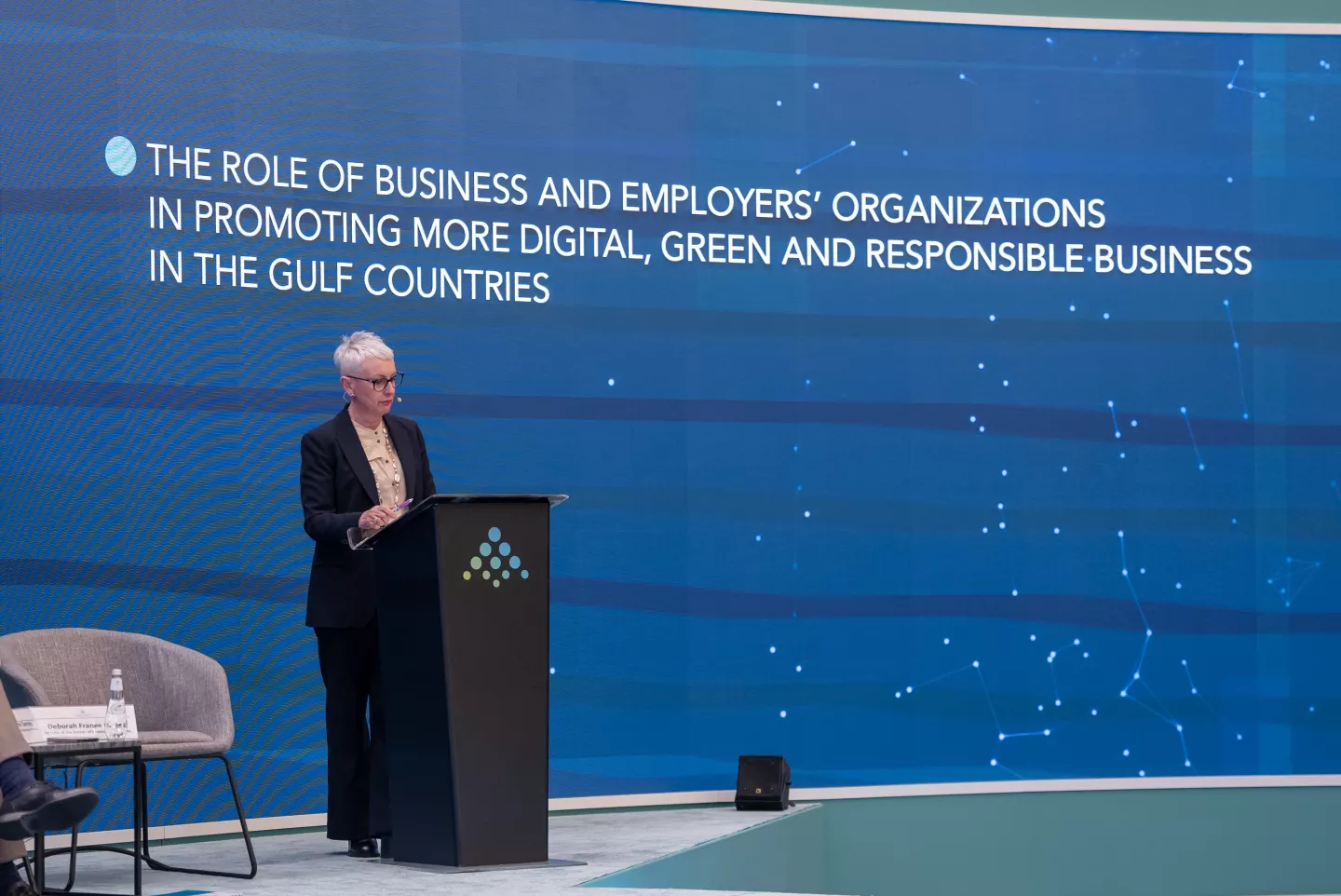 woman on podium making a statement during an event