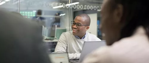 A man sitting at a desk with a laptop in front of him